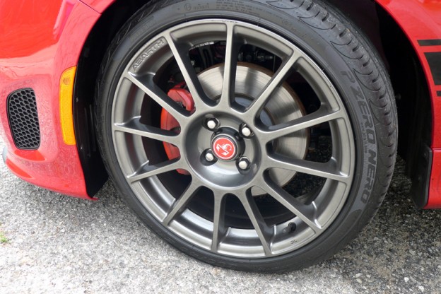A close-up of the 2013 Fiat 500 Abarth Cabrio's wheel and red brake caliper
