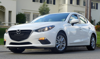 A three-quarter front view of the 2014 Mazda 3 i 4-Door Touring
