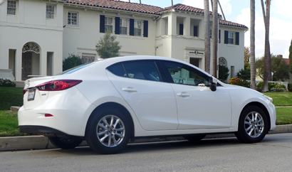 A three-quarter rear view of the 2014 Mazda 3 i 4-Door Touring